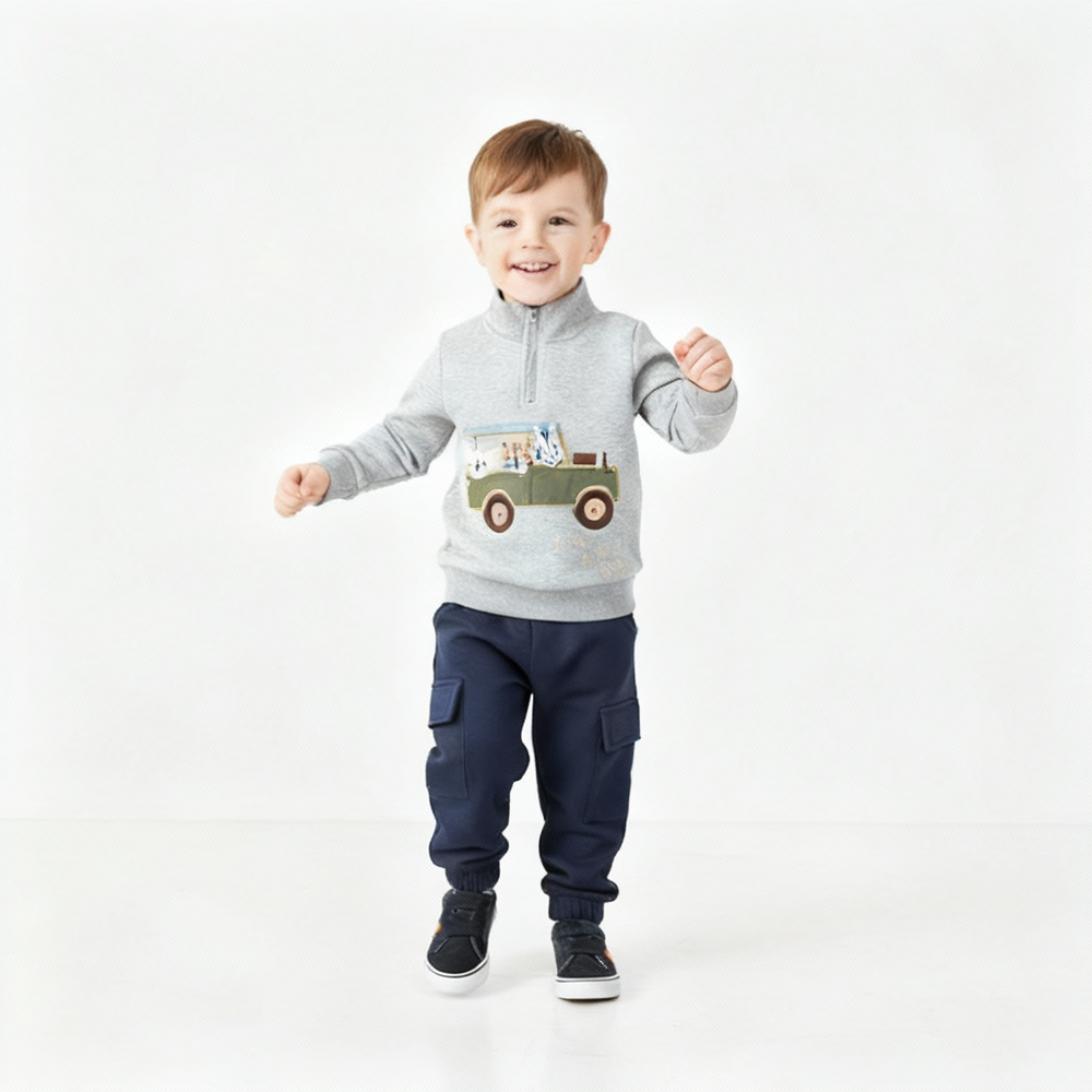Child wearing a gray sweatshirt with a truck design and navy pants on a white background