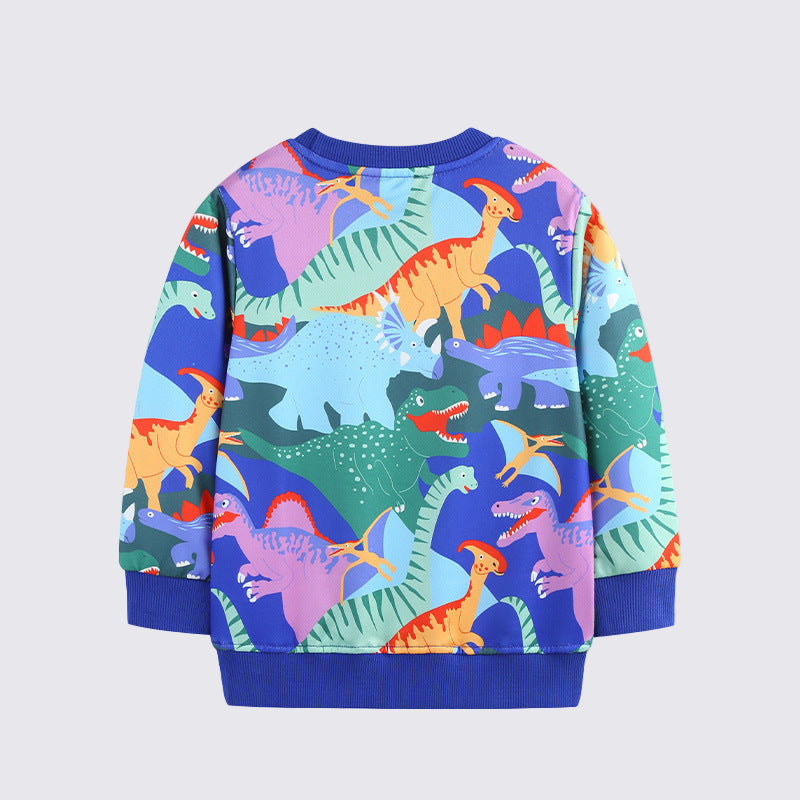 Child wearing a colorful dinosaur sweater in a room with a light background