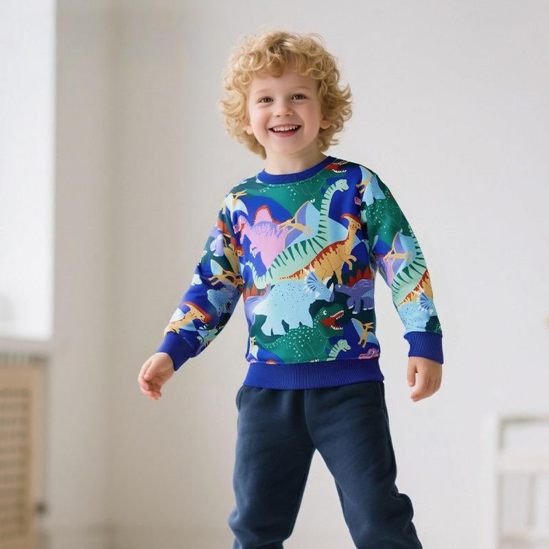 Child wearing a colorful dinosaur sweater in a room with a light background